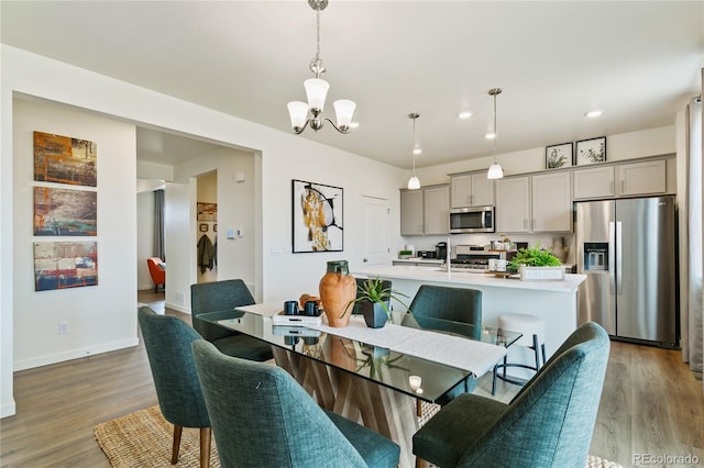 dining space with a notable chandelier and light hardwood / wood-style flooring