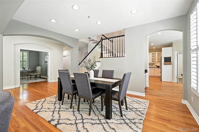 7527 E Severn Pl, Denver, CO 80230 - dining space featuring light wood-type flooring, stairs, arched walkways, and recessed lighting