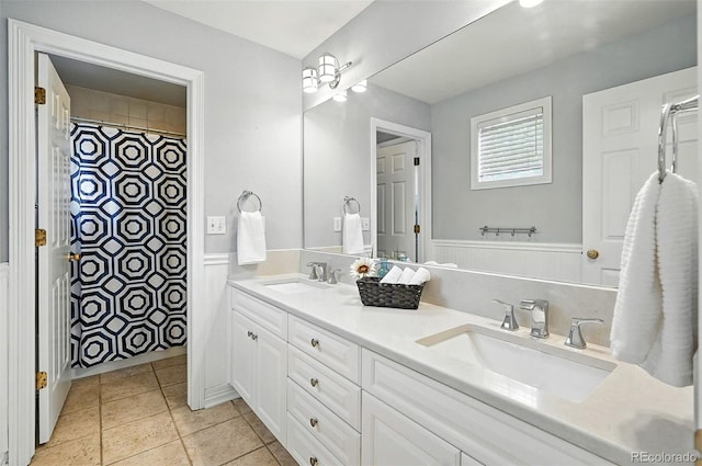7527 E Severn Pl, Denver, CO 80230 - bathroom with double vanity, tile patterned flooring, wainscoting, and curtained shower