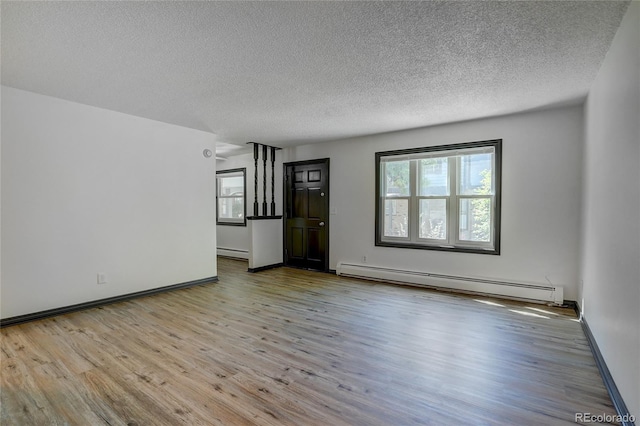 unfurnished living room with a baseboard radiator, a textured ceiling, baseboards, and wood finished floors