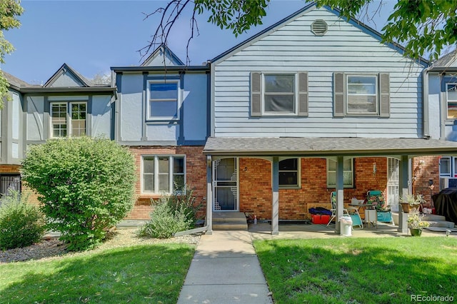 view of front facade with a front yard and brick siding