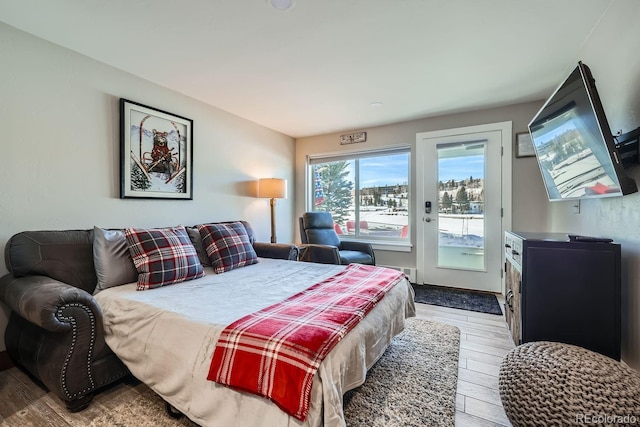 bedroom featuring wood-type flooring and access to outside