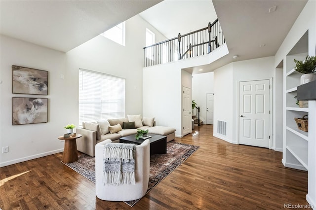 living area with visible vents, baseboards, and wood finished floors