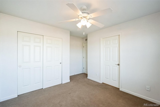 unfurnished bedroom featuring a closet, baseboards, carpet, and a ceiling fan