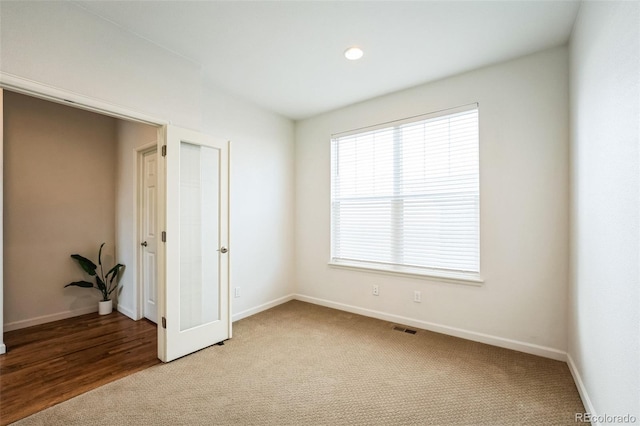 unfurnished bedroom featuring visible vents, baseboards, and light colored carpet