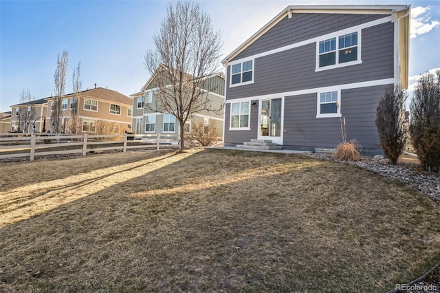 rear view of house featuring fence and entry steps