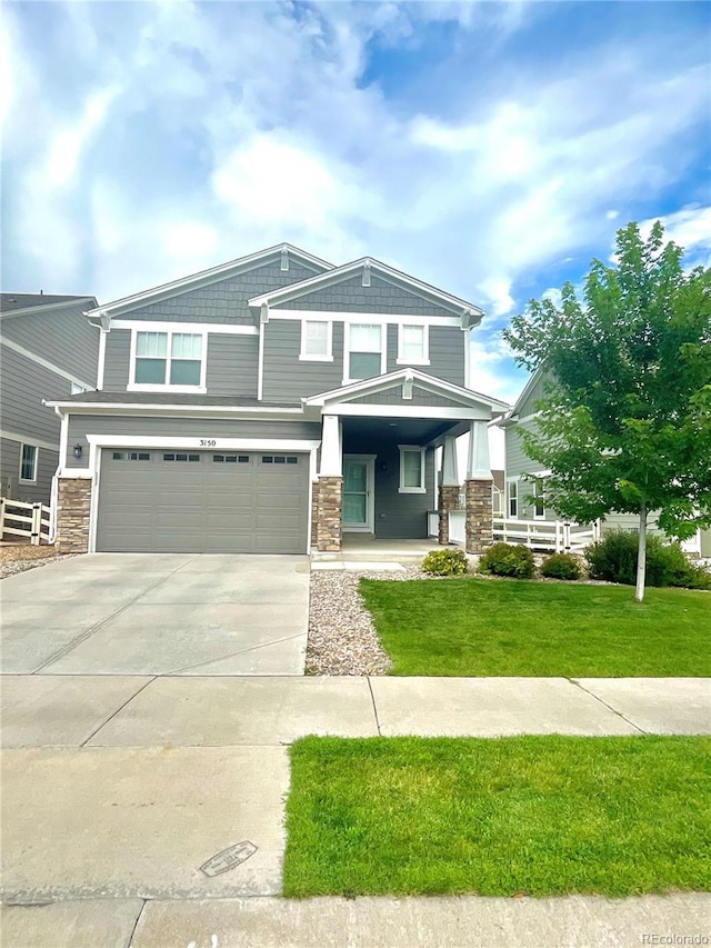 view of front of house with a front yard, driveway, a porch, stone siding, and a garage