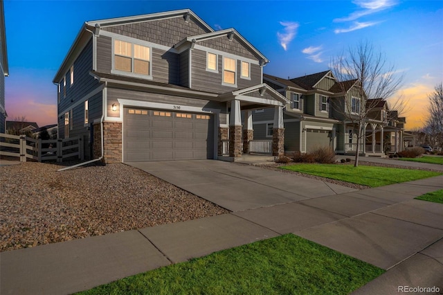 view of front facade featuring fence, a residential view, concrete driveway, a garage, and stone siding