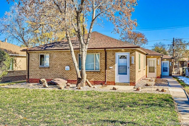 view of front of house featuring brick siding and a front lawn