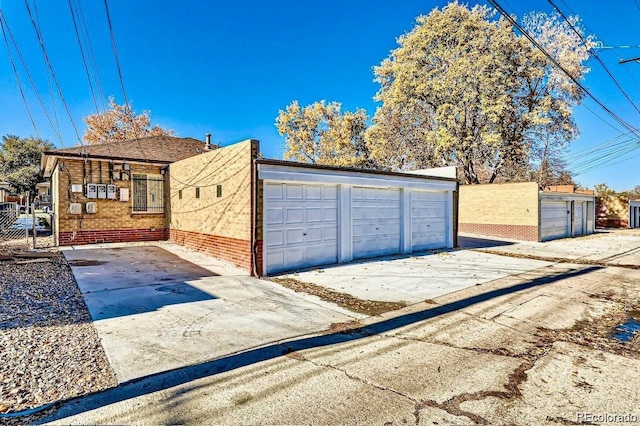 exterior space with a detached garage and brick siding