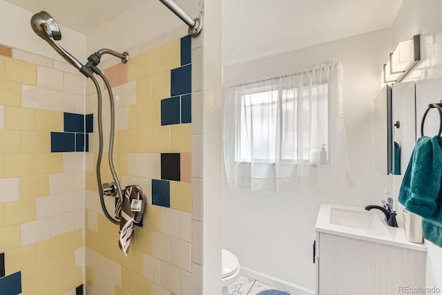 bathroom with tile patterned flooring, toilet, vanity, and a tile shower