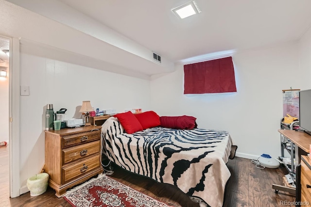 bedroom featuring visible vents, baseboards, and dark wood-type flooring