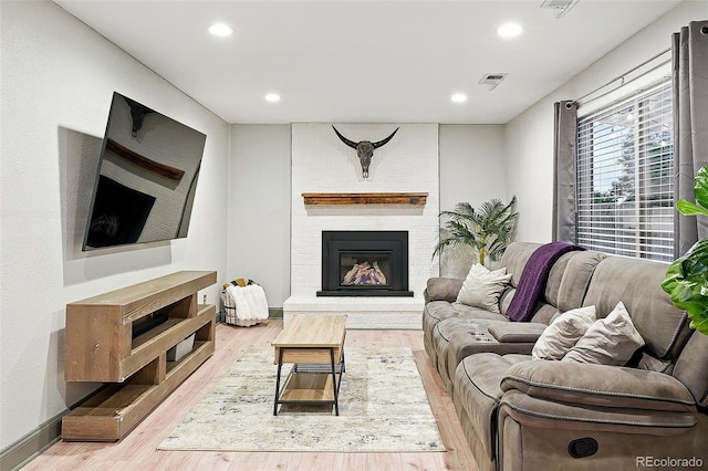 15034 E Floyd Ave, Aurora, CO 80014 - living room featuring wood finished floors, recessed lighting, a brick fireplace, and baseboards