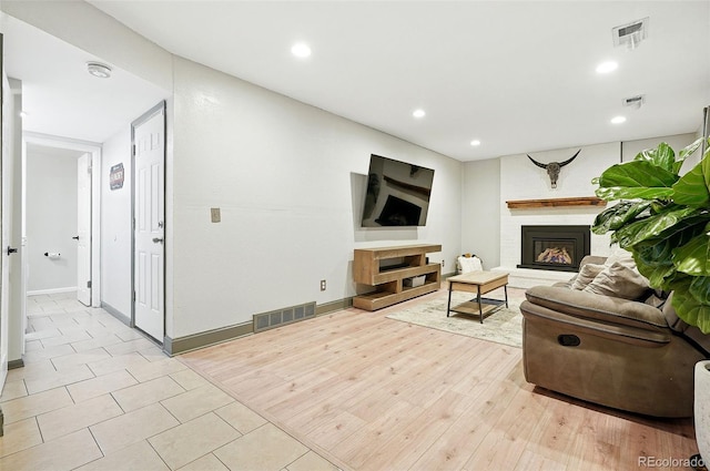 15034 E Floyd Ave, Aurora, CO 80014 - living area featuring a large fireplace, recessed lighting, baseboards, and light wood-style floors