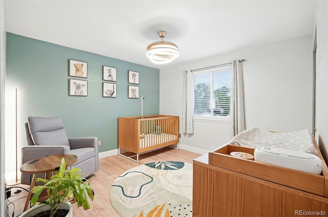 15034 E Floyd Ave, Aurora, CO 80014 - bedroom with light wood-type flooring, baseboards, and a nursery area