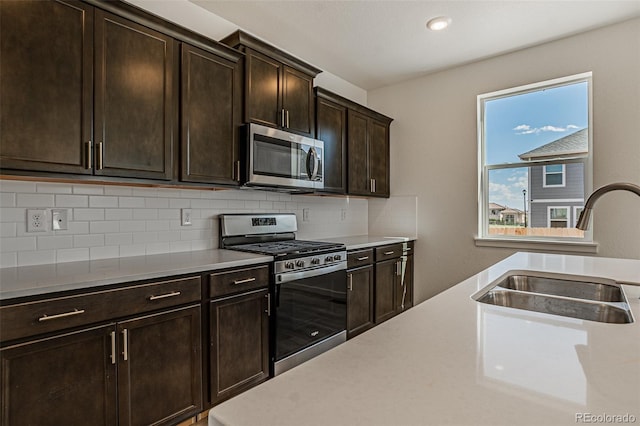 kitchen featuring stainless steel appliances, sink, decorative backsplash, and dark brown cabinets