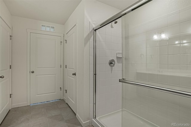 bathroom featuring a shower with door and tile patterned floors