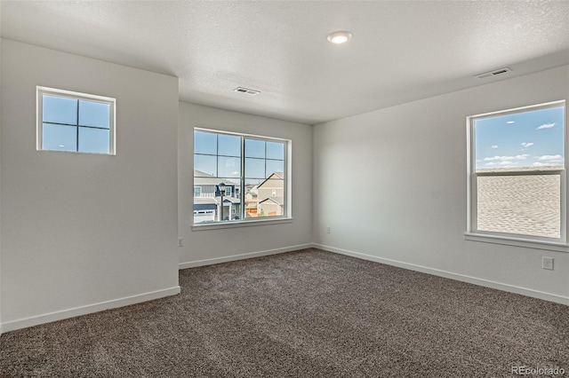 unfurnished room featuring a textured ceiling and carpet flooring