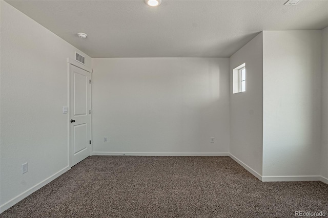 empty room with a textured ceiling and carpet flooring