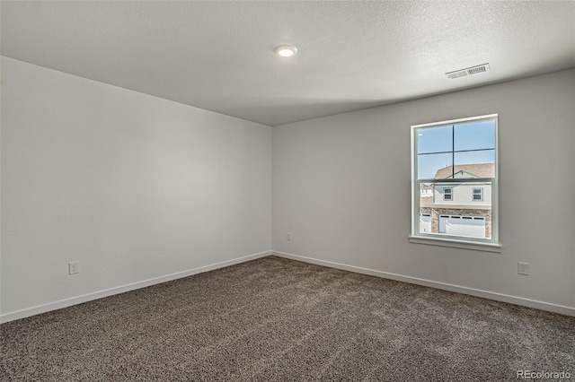 carpeted empty room featuring a textured ceiling