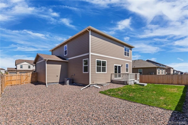 back of property with a wooden deck, a yard, and central air condition unit