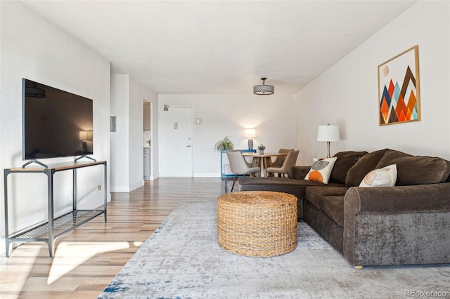 living area with baseboards and wood finished floors