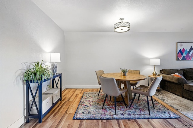 dining area featuring baseboards and wood finished floors