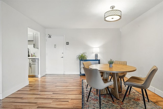 dining area featuring light wood-style floors and baseboards