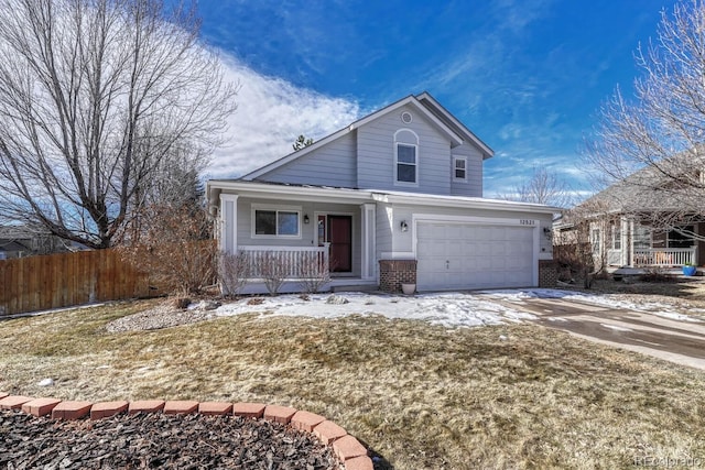 traditional-style home featuring a porch, brick siding, fence, driveway, and a front lawn