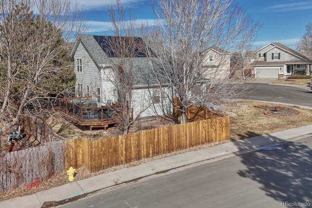 exterior space featuring driveway, a fenced front yard, and a garage