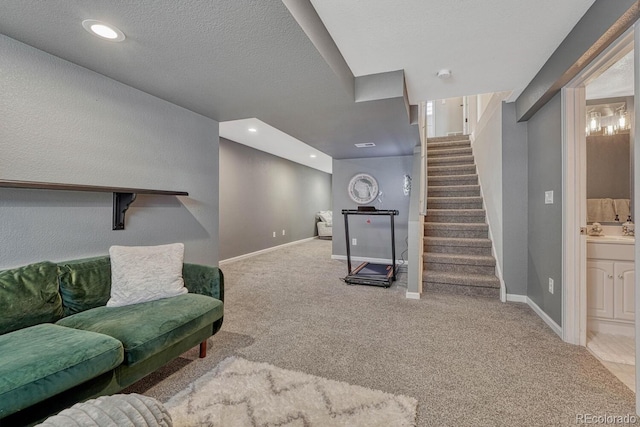 living area featuring light carpet, baseboards, stairs, a textured ceiling, and recessed lighting