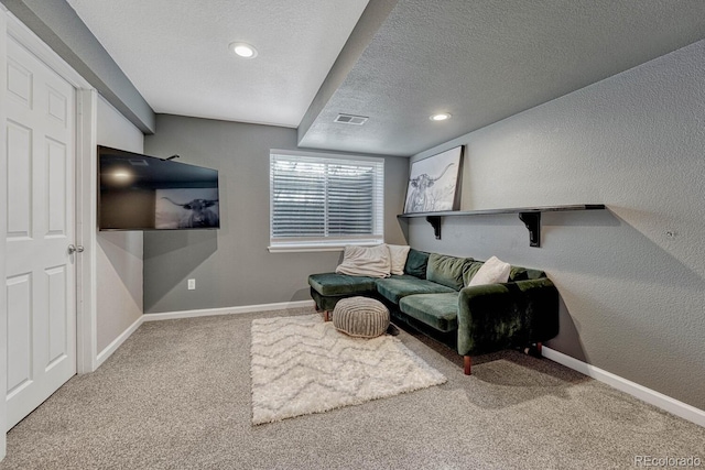 sitting room with carpet floors, visible vents, a textured wall, a textured ceiling, and baseboards