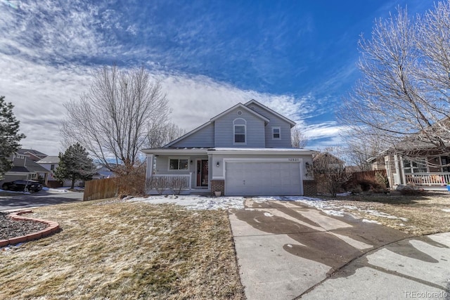 traditional-style home with concrete driveway, an attached garage, covered porch, fence, and brick siding