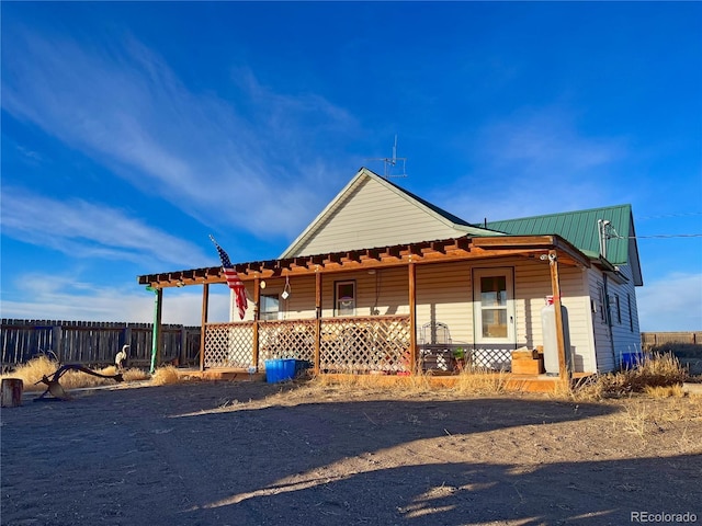 view of side of home featuring covered porch