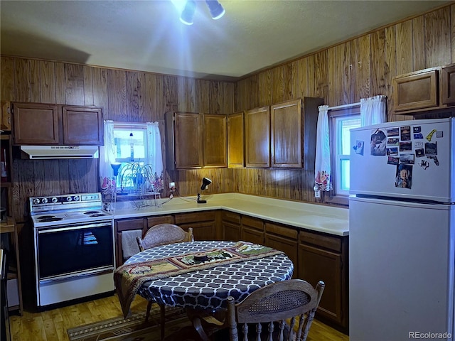 kitchen with white appliances and light hardwood / wood-style flooring