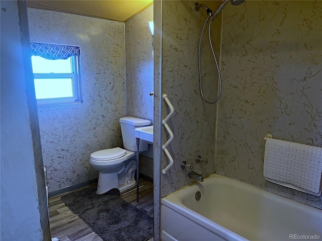 bathroom with hardwood / wood-style floors, shower / bathtub combination, and toilet