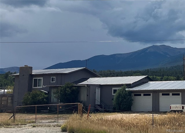 35805 US Highway 24, Buena Vista, CO 81211 - ranch-style house featuring an attached garage, a mountain view, metal roof, and a chimney