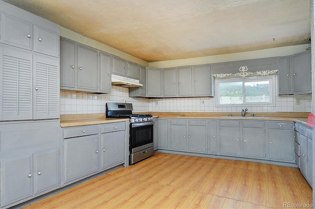 35805 US Highway 24, Buena Vista, CO 81211 - kitchen featuring stainless steel range with gas cooktop, gray cabinetry, under cabinet range hood, and light wood-style flooring