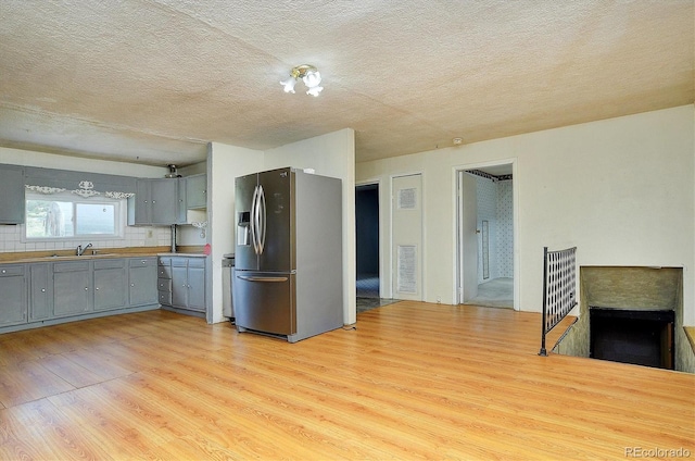 35805 US Highway 24, Buena Vista, CO 81211 - kitchen featuring stainless steel fridge with ice dispenser, gray cabinets, light wood finished floors, a textured ceiling, and light countertops