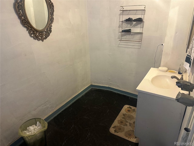 bathroom with baseboards, concrete flooring, and vanity