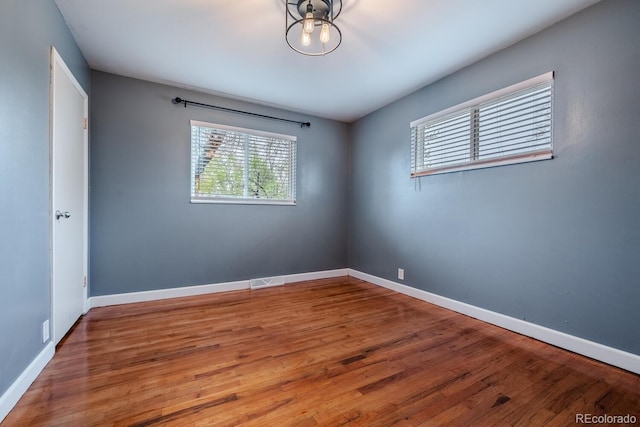 empty room featuring wood finished floors and baseboards