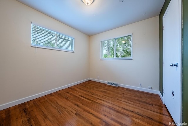empty room featuring baseboards and wood finished floors