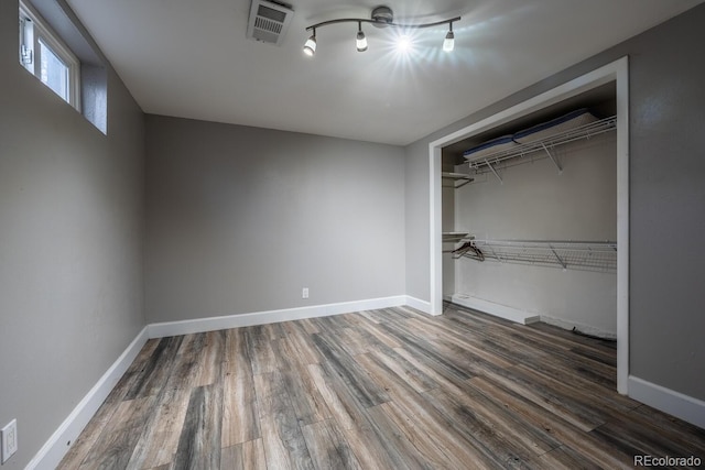 unfurnished bedroom featuring wood finished floors, a closet, and baseboards