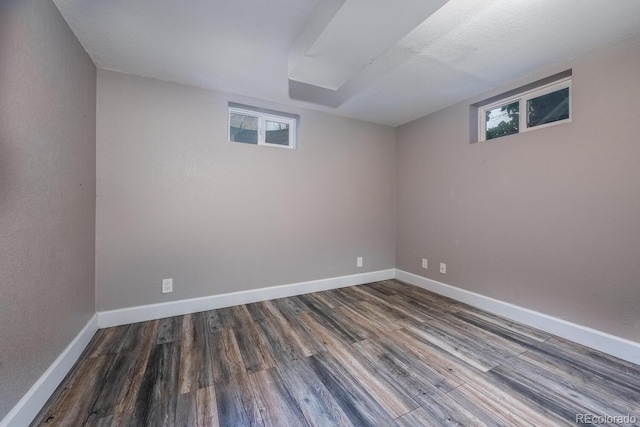below grade area with wood finished floors, plenty of natural light, and baseboards