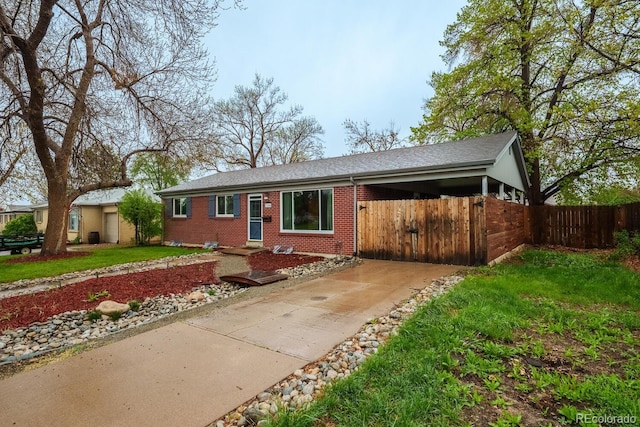 single story home with brick siding, driveway, fence, a gate, and roof with shingles