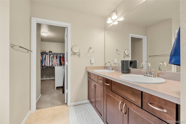 11235 S Neu Towne Cir, Parker, CO 80134 - bathroom featuring double vanity, tile patterned flooring, a walk in closet, and baseboards