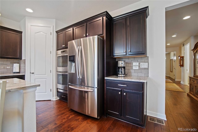 25536 E 1st Ave, Aurora, CO 80018 - kitchen featuring appliances with stainless steel finishes, dark brown cabinetry, tasteful backsplash, dark wood-type flooring, and recessed lighting