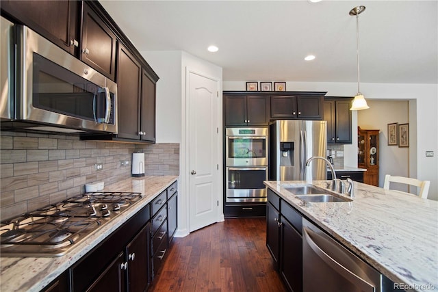 25536 E 1st Ave, Aurora, CO 80018 - kitchen with appliances with stainless steel finishes, light stone counters, dark wood-style floors, dark brown cabinets, and decorative backsplash