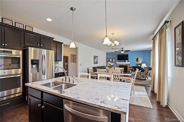 25536 E 1st Ave, Aurora, CO 80018 - kitchen with appliances with stainless steel finishes, a chandelier, open floor plan, dark wood-type flooring, and an island with sink