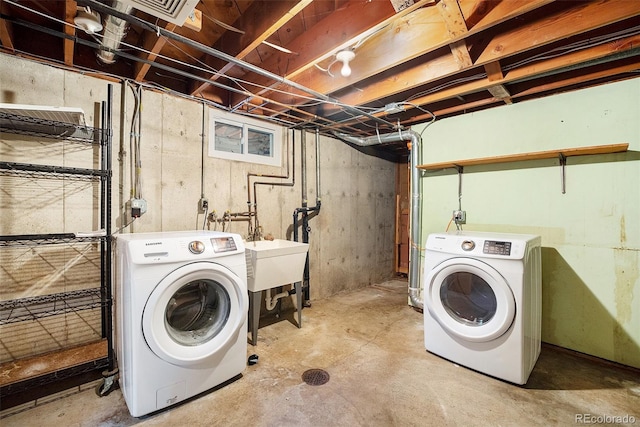 laundry area with a sink, laundry area, washing machine and dryer, and visible vents